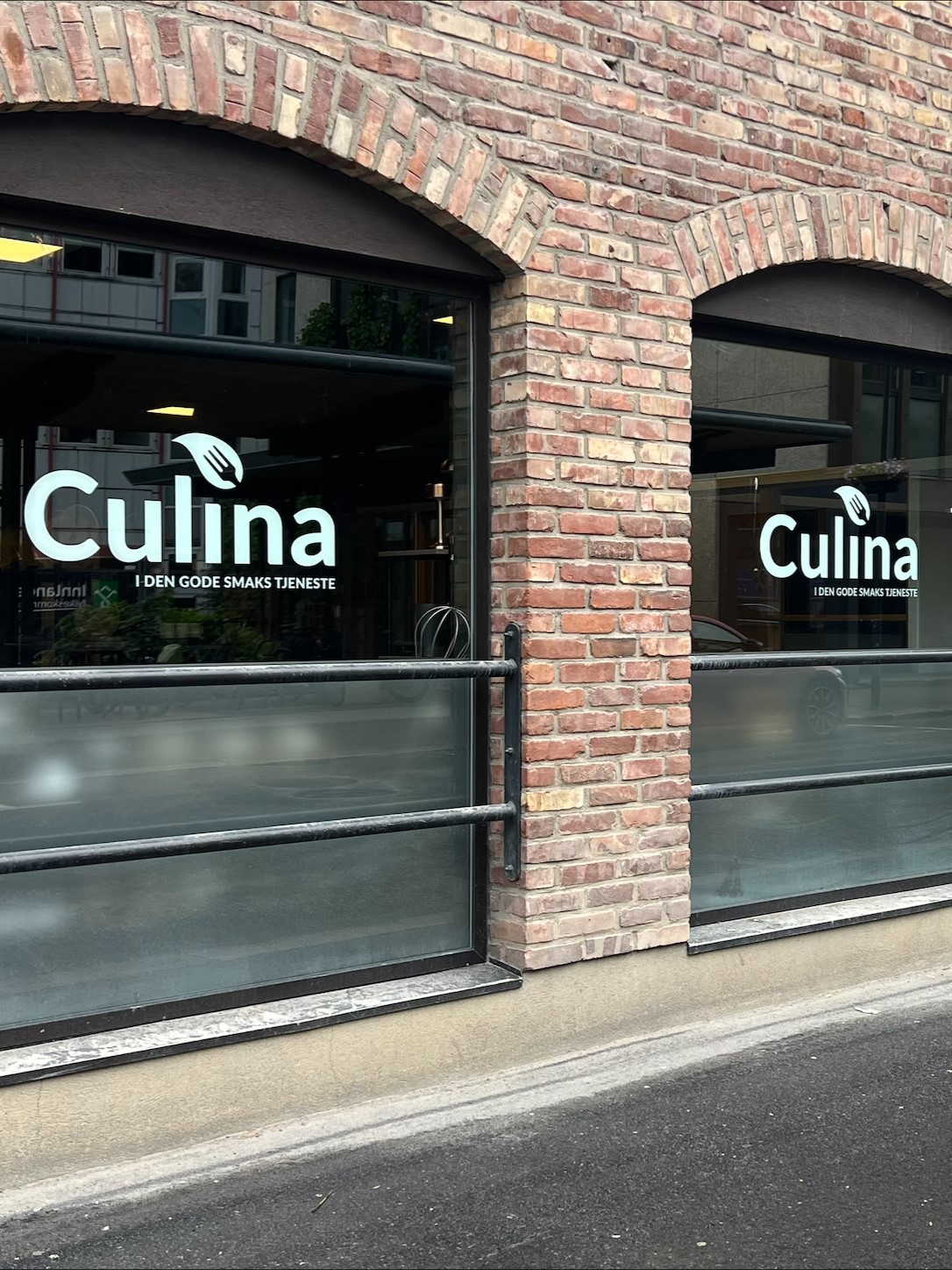 Fasade med Culina-logo på vinduer i mursteinsbygning med buede vinduer